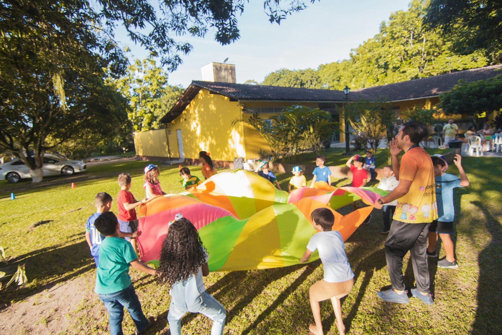 a group of kids holding a large parachute